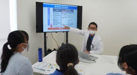 本学について紹介をする櫻庭教授と説明を受ける中学生