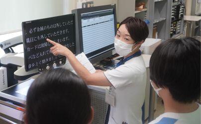 成島助教より設備について解説を受ける様子