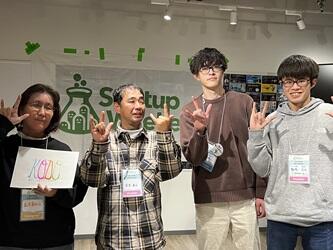 写真は、2位を受賞したKODOの皆さんとの集合写真で、一番右が飯塚さん、右から二番目が山田さんです。