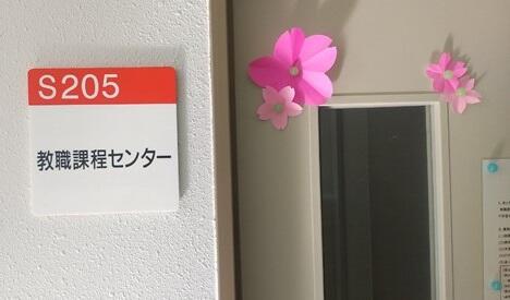 教職課程センターの部屋の表示。壁に看板、ドアに桜の飾りがついている。