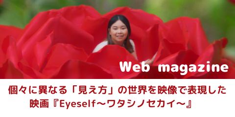 ムービーのひとコマ。大きな赤い花の中に八染さんが座っている。