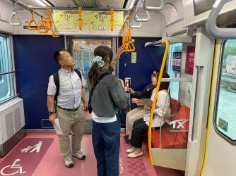 視覚コースの学生が吊り革の高さを確かめている様子