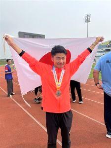 銀メダルを首にかけ、日本の国旗を掲げた中村さんの写真